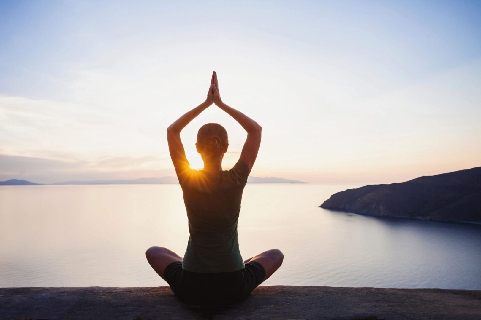 A person sitting in the middle of a yoga pose.